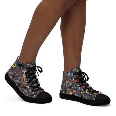 High top canvas shoes with a colorful pattern, featuring a lace-up front and black outsole, worn by a person.